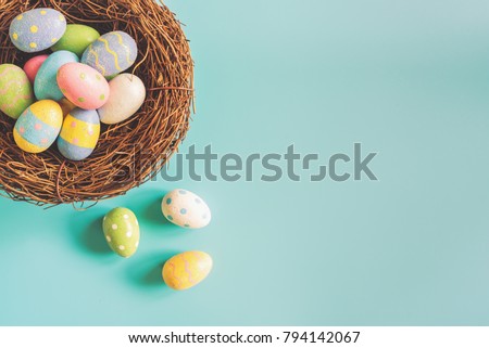 Coloeful easter eggs in nest on pastel color background with space. Royalty-Free Stock Photo #794142067
