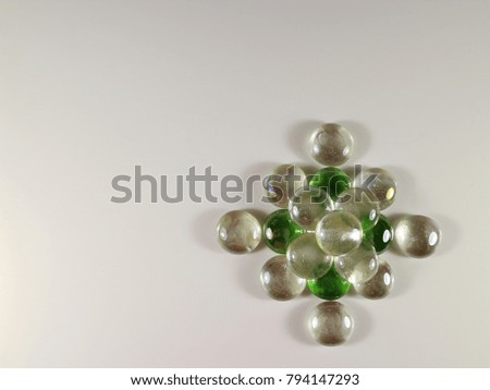 shiny, transparent and green decorative pebbles on a white background