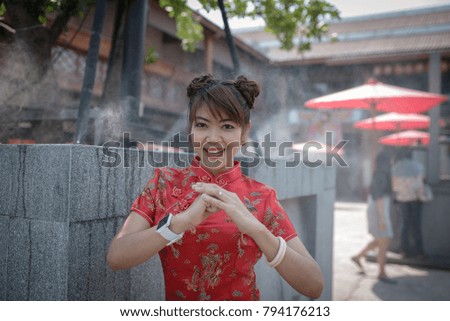Portrait of beautiful asian chinese brunette woman wearing red,She's blessed for the Chinese New Year,Let's get rich, trade profit, rich money, good health.