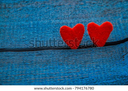 happy valentines day. Two red heart shapes stand in crack of blue wooden board texture