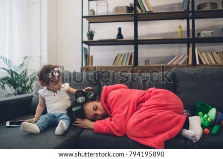 Young mother old is experiencing postnatal depression. Sad and tired woman with PPD. She does not want to play with her daughter