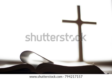 Holy Bible on the background of the Christian cross and the life-giving divine light. The hope of mankind for salvation. The way to God through prayer. The Resurrection and Rapture of Jesus. Royalty-Free Stock Photo #794217157