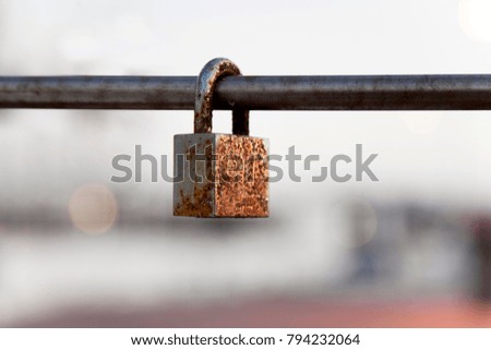 Closed padlock in a rusty ion rod
