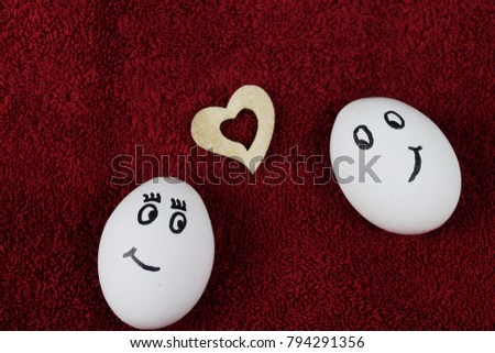 close up of two valentines day eggs with a heart on a red fluffy background 