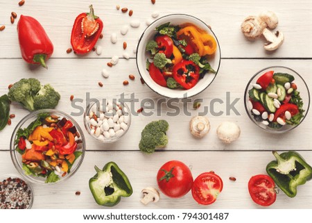 Cooking assorted vegetable salads on white wood top view. Fresh organic snack for vegetarian party food table. Mockup for menu, recipe or culinary classes