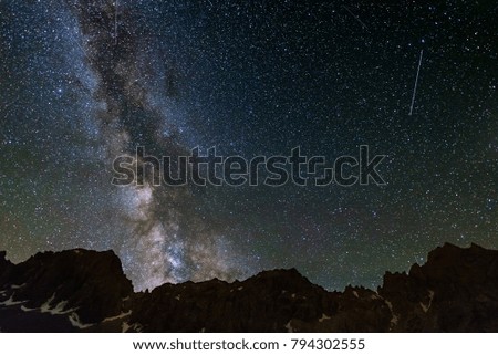 Milky Way starry sky rocky mountains profile silhouette captured from high altitude on the Alps.