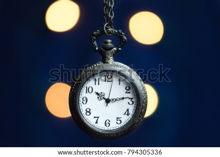 Ancient pocket watch with blurry light bokeh background