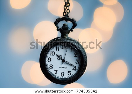 Ancient pocket watch with blurry light bokeh background