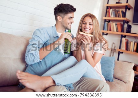 Picture of happy romantic couple eating pizza at home.