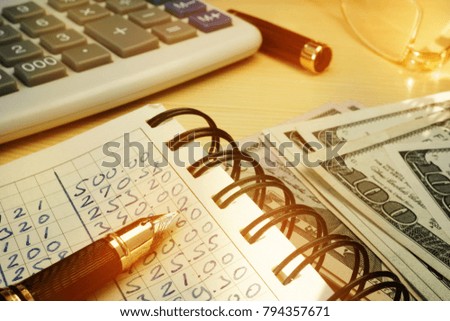 Budgeting money. Book with calculations, calculator and dollars.