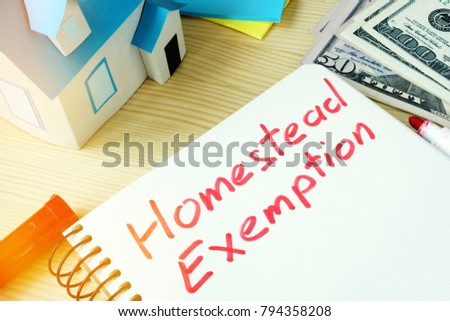 Man writing Homestead Exemption in a note pad. Royalty-Free Stock Photo #794358208