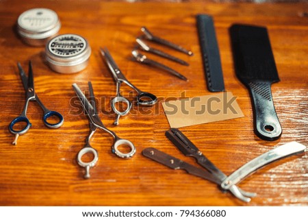 tools for hairstyles, scissors, razors, and an empty business card. place for text typing. the usual set of devices in the barbershop