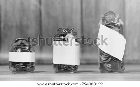 Coins in a jar on the floor. Accumulated coins on the floor. Pocket savings in piles.