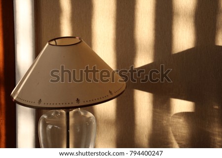 A lamp in the shadow of blinds