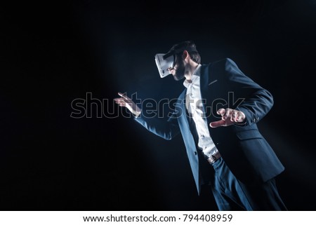 Virtual dimension. Professional handsome positive businessman being in 3d reality and moving his hands while using virtual reality glasses