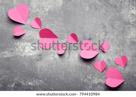 Pink paper hearts on grey wooden table