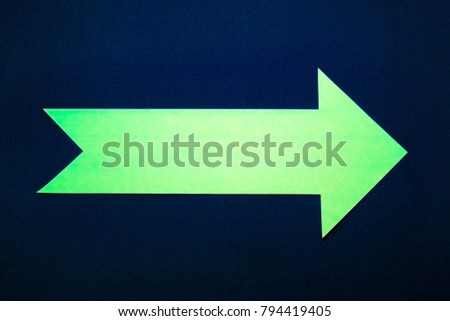 Green paper right arrow on dark blue background