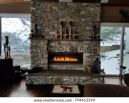 Stone Fireplace with Flames a-Glow, Rustic Style in Brown and Grey Tones, Cozy Home in Winter