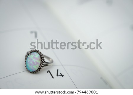 Opal rings put on calendar on February 14, Valentine or Wedding concept.
