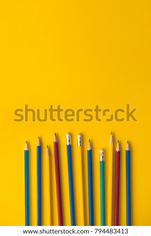 Set of colorful pencils on yellow paper with copy space, educational bakground concept