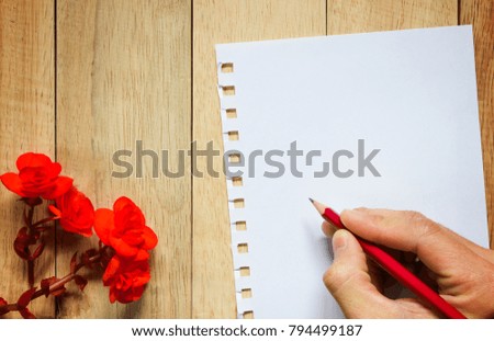 Red rose and paper for message on wooden background. Image of Valentines day.