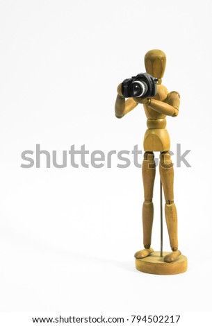 Wooden puppet stand on white background and hold camera. Photography and tourism concept
