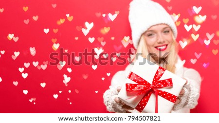 Young woman holding a gift box with heart lights