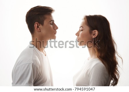 Young woman and man in love standing with closed eyes. Love is in the air, those who jealous, try not to breathe. They do not care about the rest, because in their universe only two of them exist. Royalty-Free Stock Photo #794591047