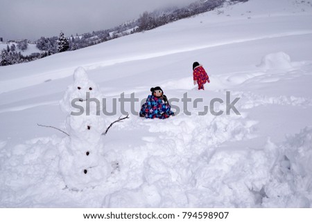 Children making snowman playing