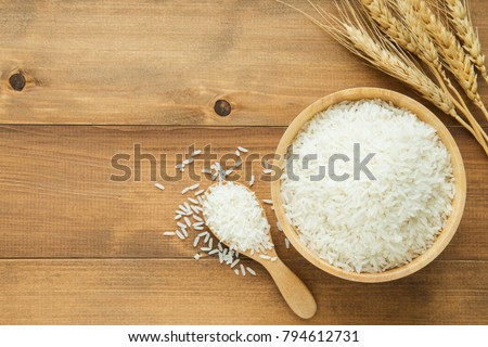 white rice (Thai Jasmine rice) in wooden bowl on wood background Royalty-Free Stock Photo #794612731