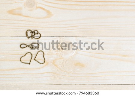 Valentine's day / endless love or special occasion concept : Top / overhead view of many brass heart on wood texture background with copy space. Depicts infinite love passion for romantic couple.