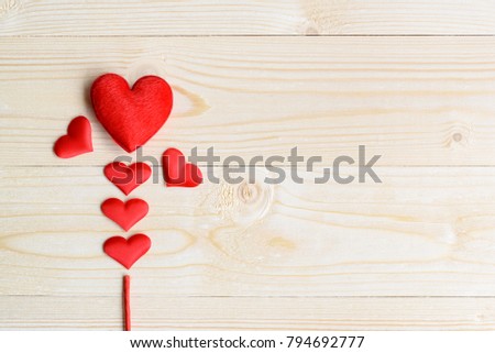 Valentine's day / endless love or special occasion concept : Top / overhead view of six red heart with a red stick on wood texture background with copy space. Depicts love passion for romantic couple.