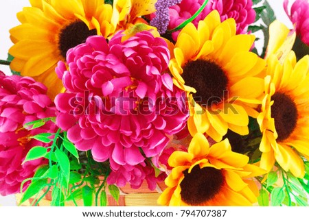 Colorful fabric flowers in wicker basket closeup picture.