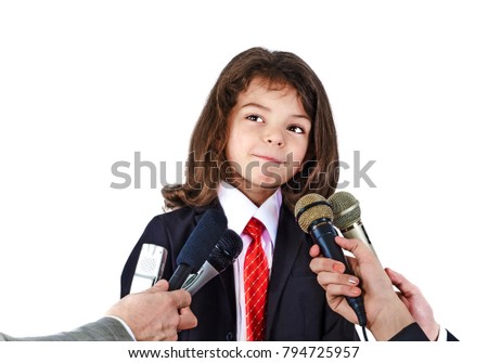 A little boy in a business suit gives an interview.