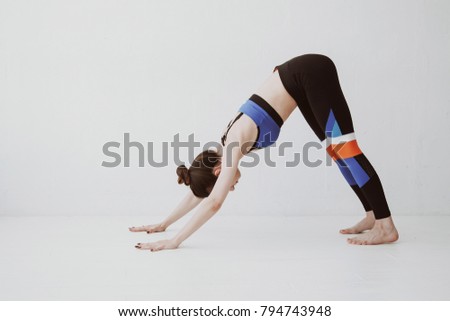 Above shot of a young woman practicing in a yoga studio. Dolphin pose, preparation for an inversion. Lifestyle.