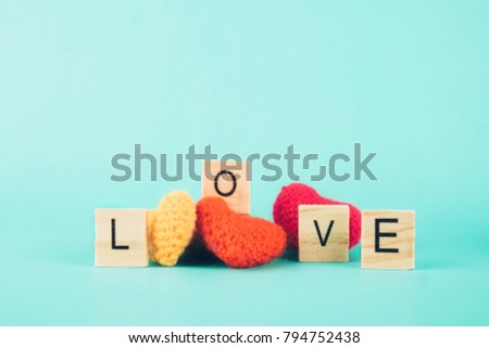 Love Valentine idea background concept. Love alphabet wood and red heart on paltel background.
