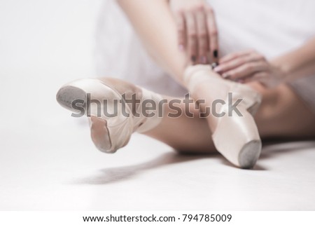 Ballerina dancer sitting down with her legs crossed