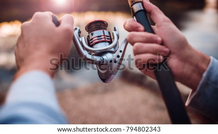 Fisherman angling on the river, close up photo. Sport, recreation, lifestyle