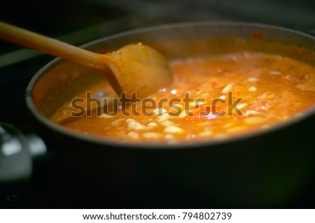 Pot of gravy or soup while cooking on the stove and is stirred to achieve the perfect cooking to be served. Royalty-Free Stock Photo #794802739
