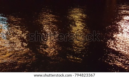 Reflection of lighting on sea water at night time texture background.
