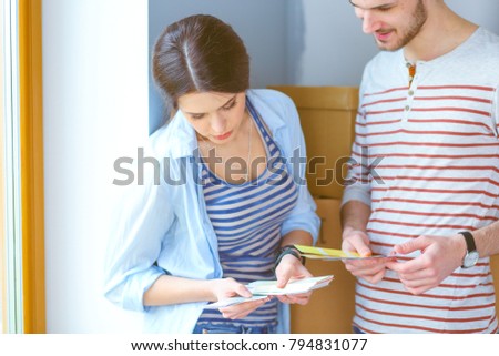 Couple choosing paint colour from swatch for new home .