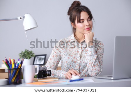 Portrait of young woman sitting at desk . young woman