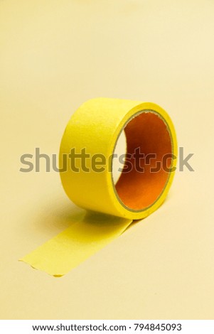 Adhesive tape roll on yellow background