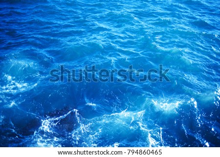 Background image of aqua sea water surface with sunny reflections, aerial view. Ocean wave close up

