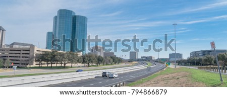 Irving, Texas skyline view from John Carpenter Freeway under winter cloud blue sky. Cityscape and transportation background. Panorama style.