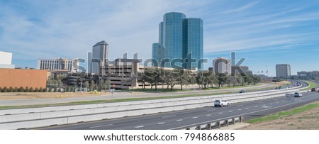 Irving, Texas skyline view from John Carpenter Freeway under winter cloud blue sky. Cityscape and transportation background. Panorama style.