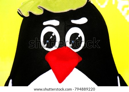 The penguin doll in big hat on bright background