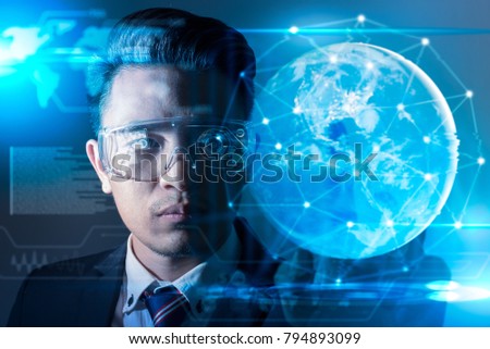 The abstract image of business man using a vr glasses overlay with earth hologram image and element of this image furnished by Nasa. the concept of communication, internet of things and future life.