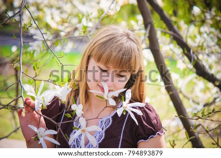 A girl in a blooming magnolia garden. Selective focus. 