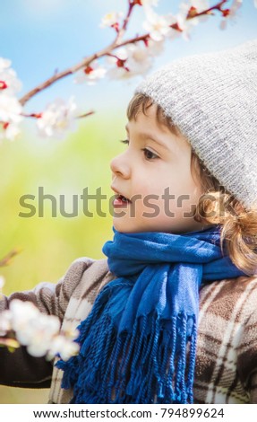 A child in a blooming garden. Selective focus. 